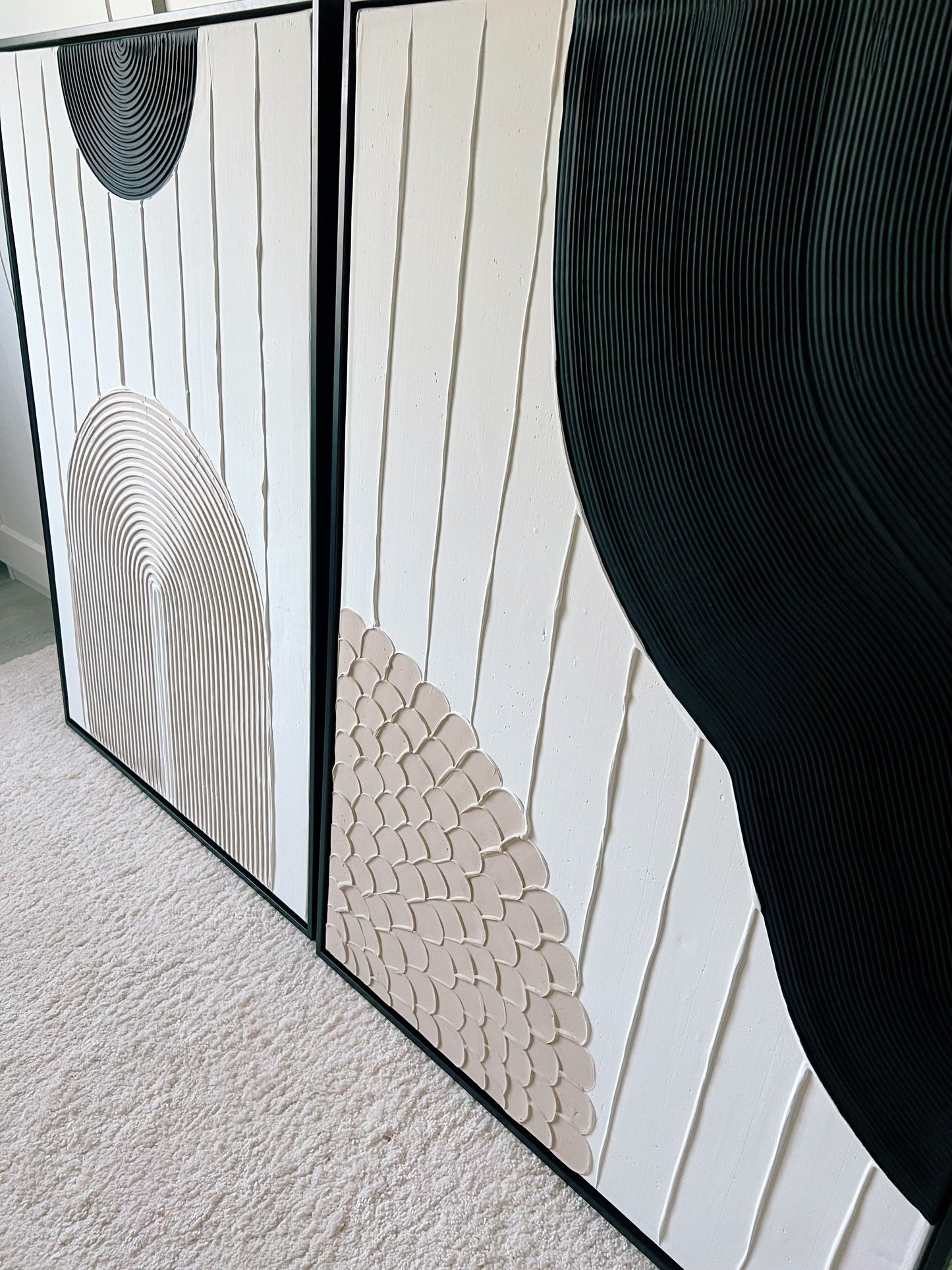 Textured canvas artwork in white and beige with bold black accents