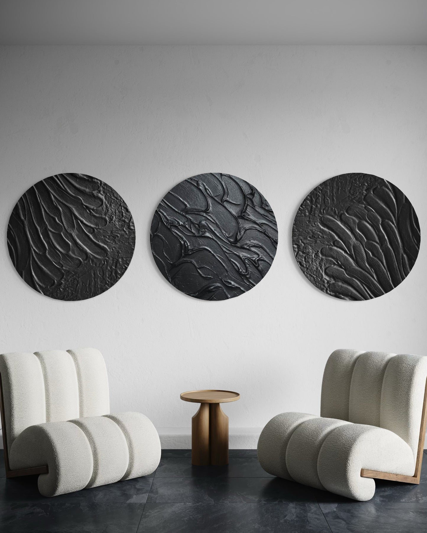 Three circular black wall art pieces in a modern room with two curved white chairs.