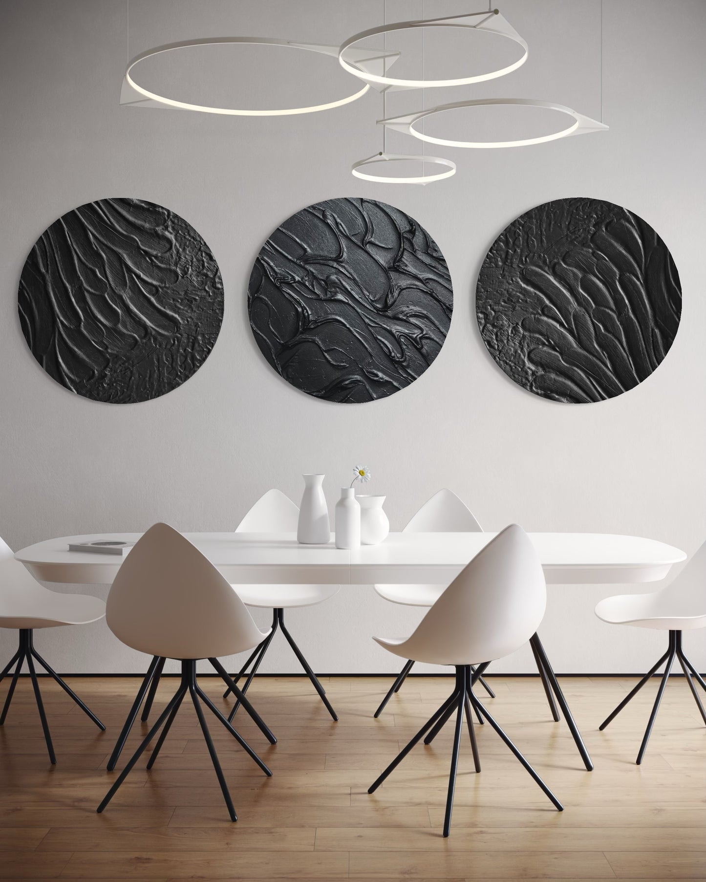 Modern dining room with white chairs, a white table, and three black circular wall art pieces.