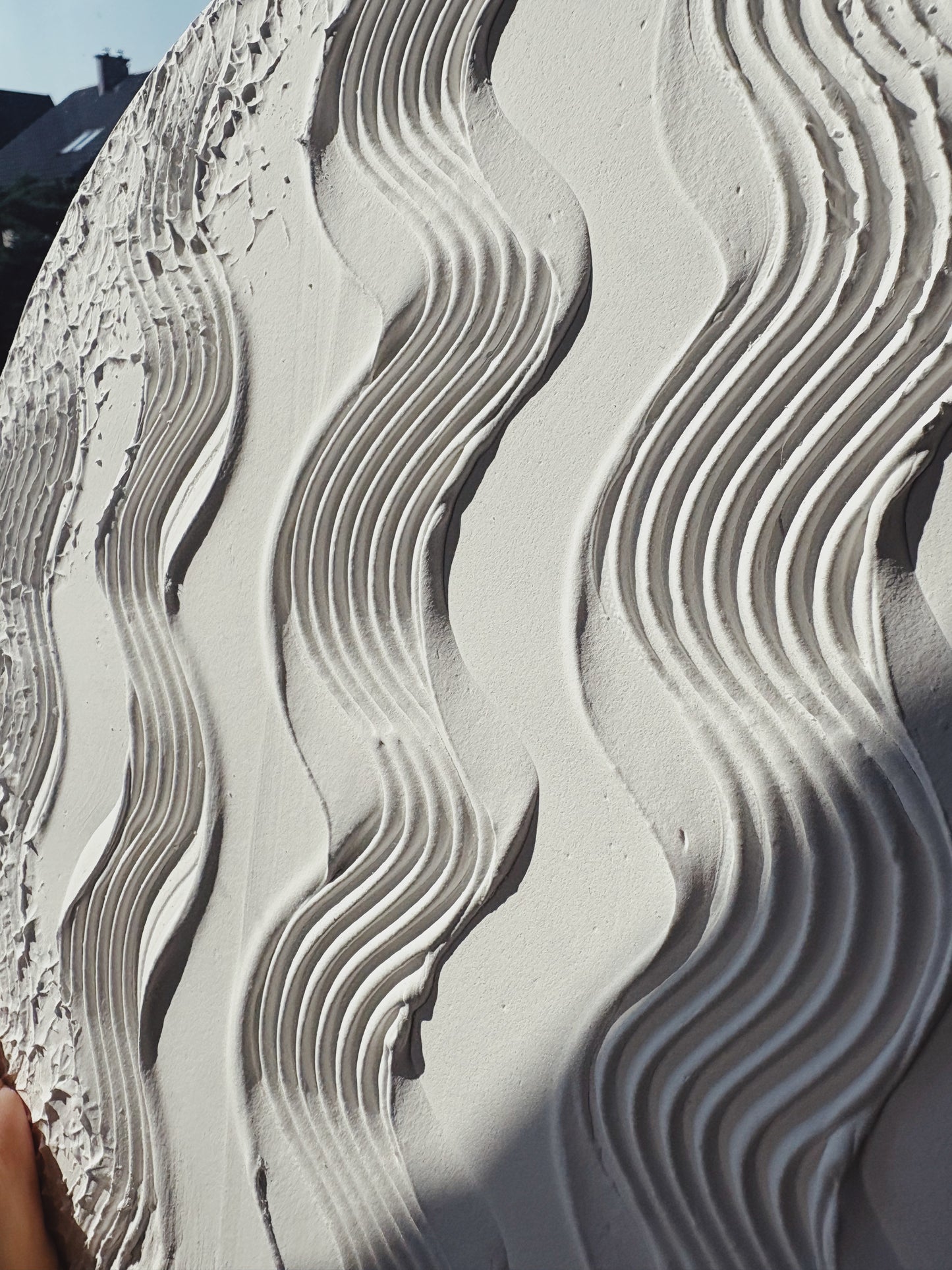 Close-up of textured wall art surface with wavy pattern