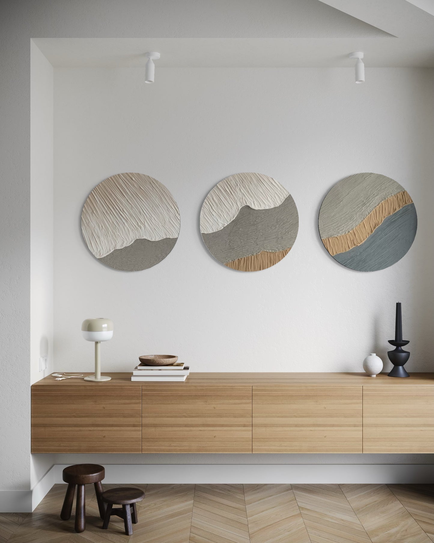 Three circular wall art pieces on a white wall above a wooden console table.