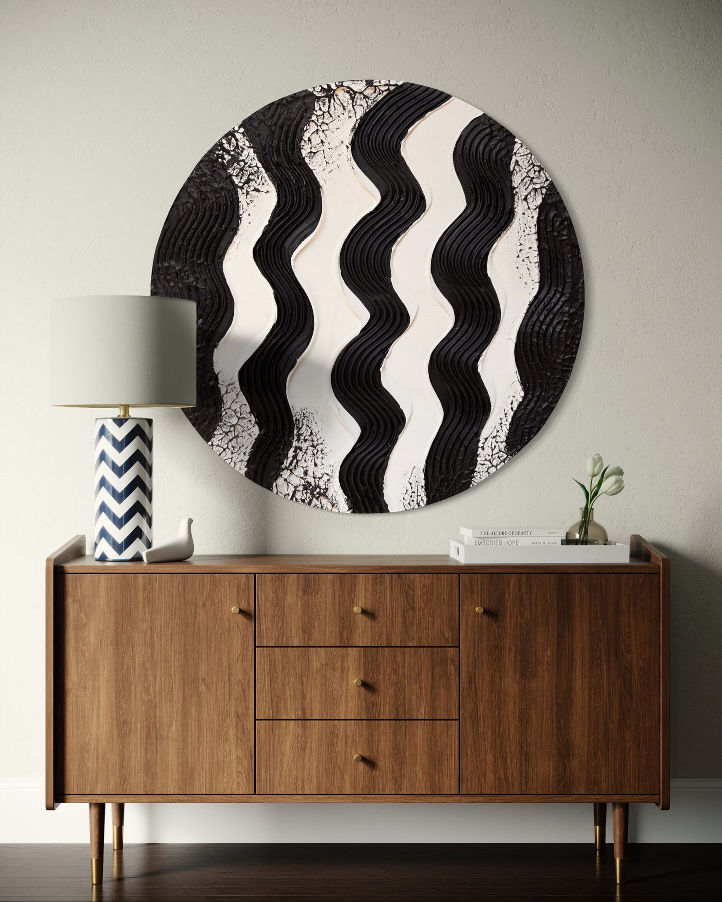 Round black and white wavy wall art above a wooden sideboard with decorative items.