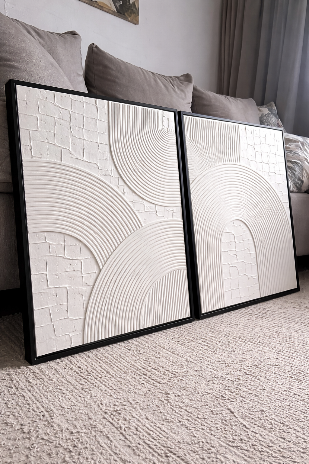 Two abstract wall art pieces in a living room setting.