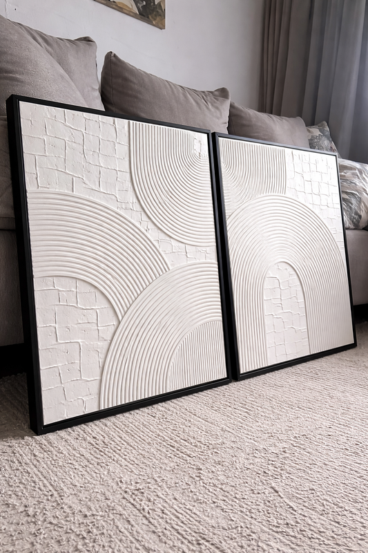 Two abstract wall art pieces in a living room setting.