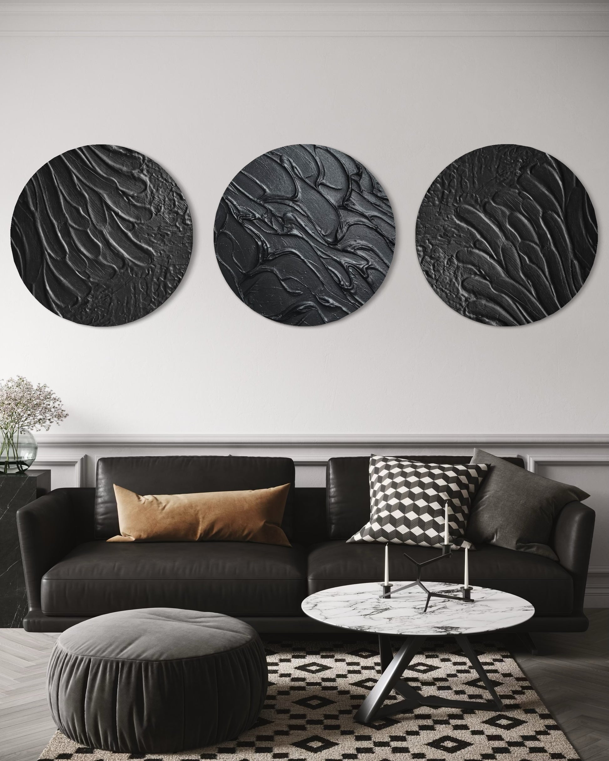 Three round black wall art pieces above a black sofa with decorative pillows in a living room setting.