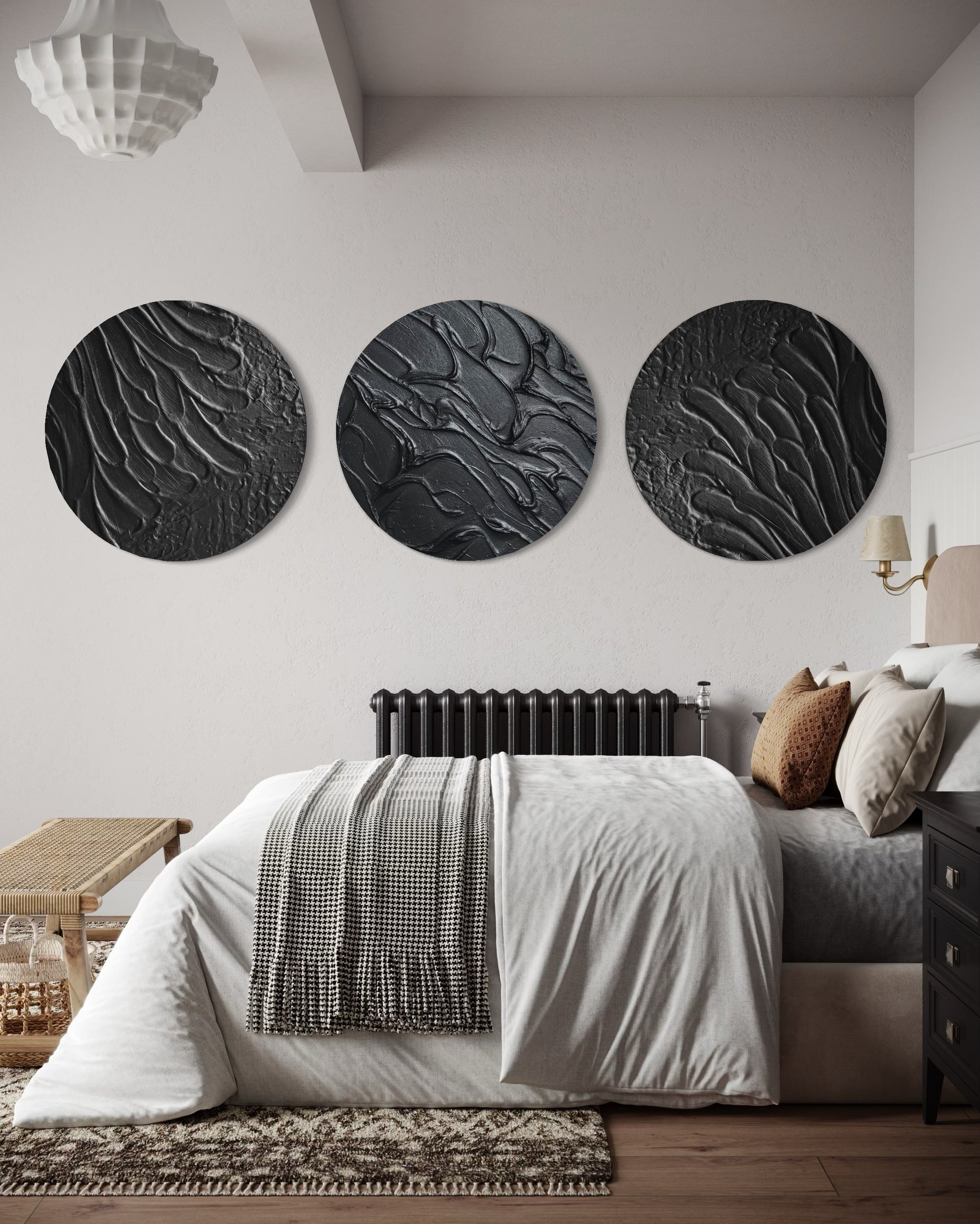 Three circular black wall art pieces on a white wall above a bed in a bedroom.