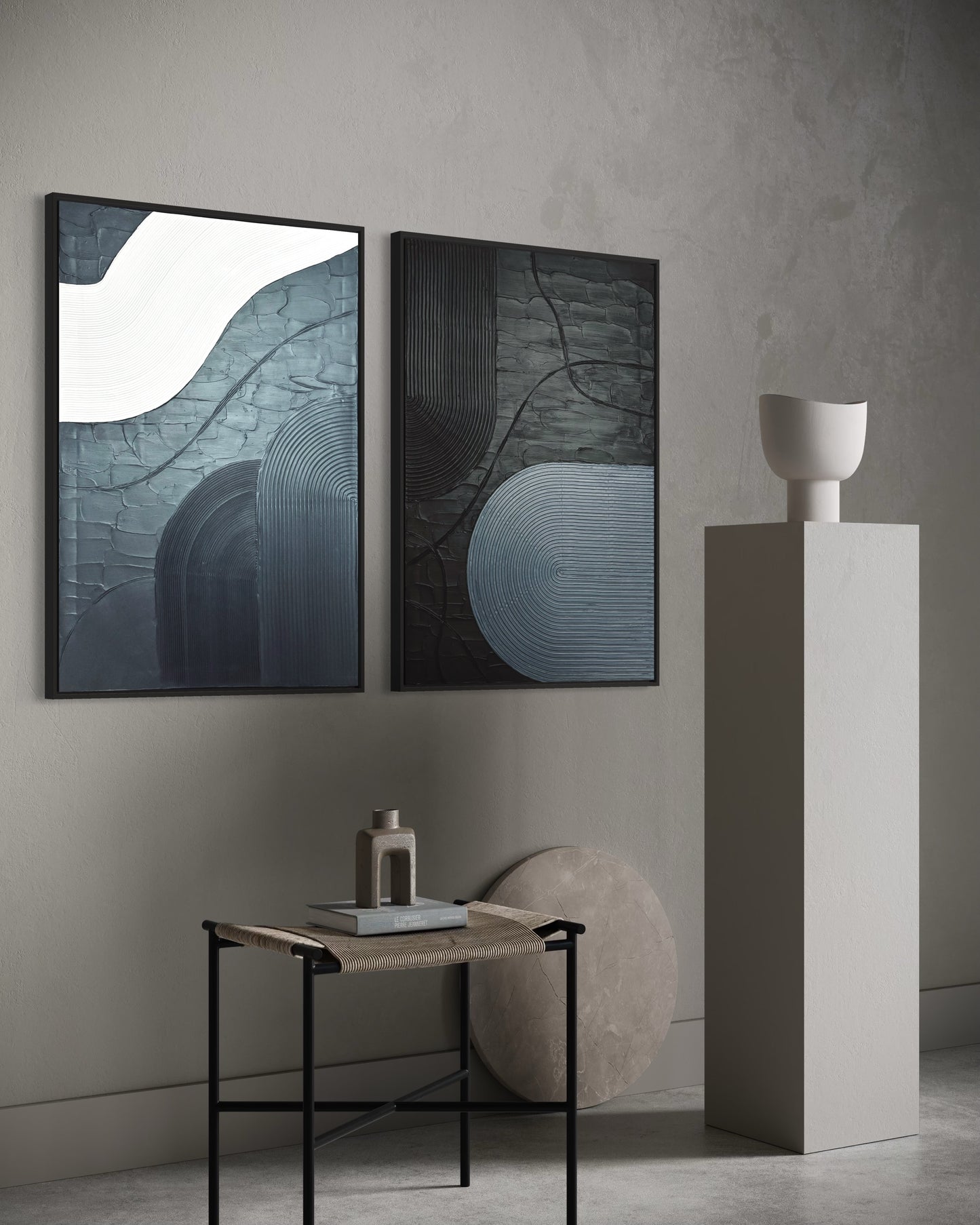 Two abstract paintings on a wall with a small table and decorative items in a minimalistic setting.
