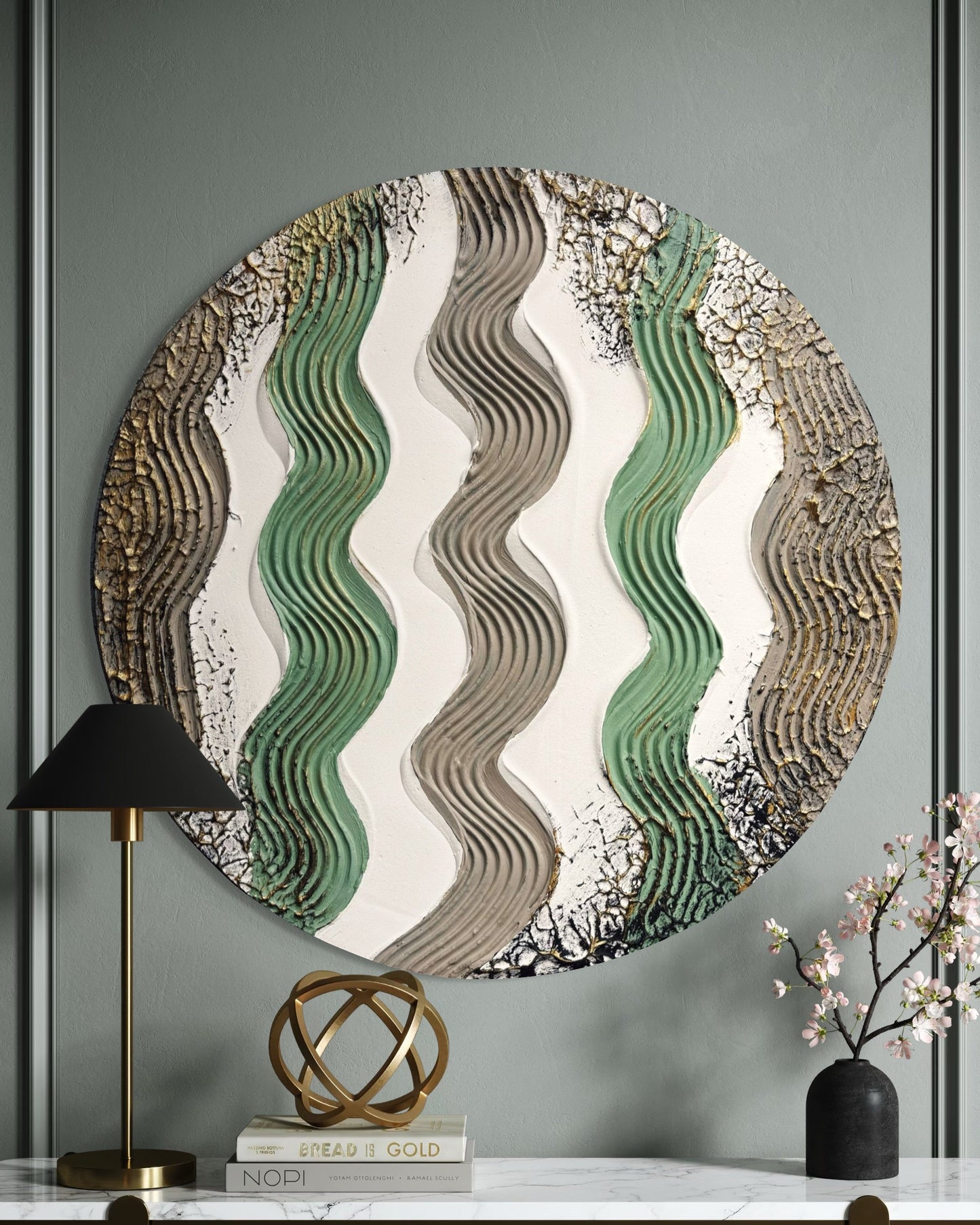 Modern round textured wall art with wavy patterns on a gray wall above a marble console table.