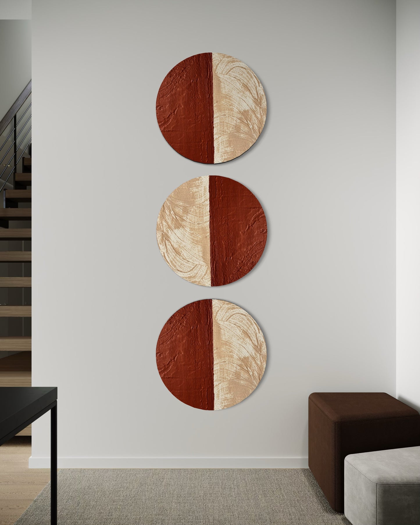 Three circular wall art pieces with a two-tone design on a gray wall.