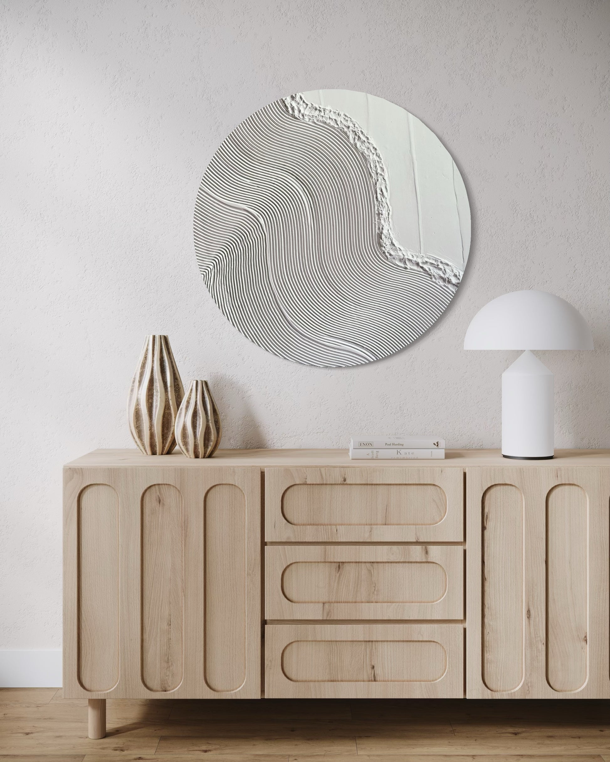 Wooden sideboard with decorative wall art and vases in a minimalistic room.