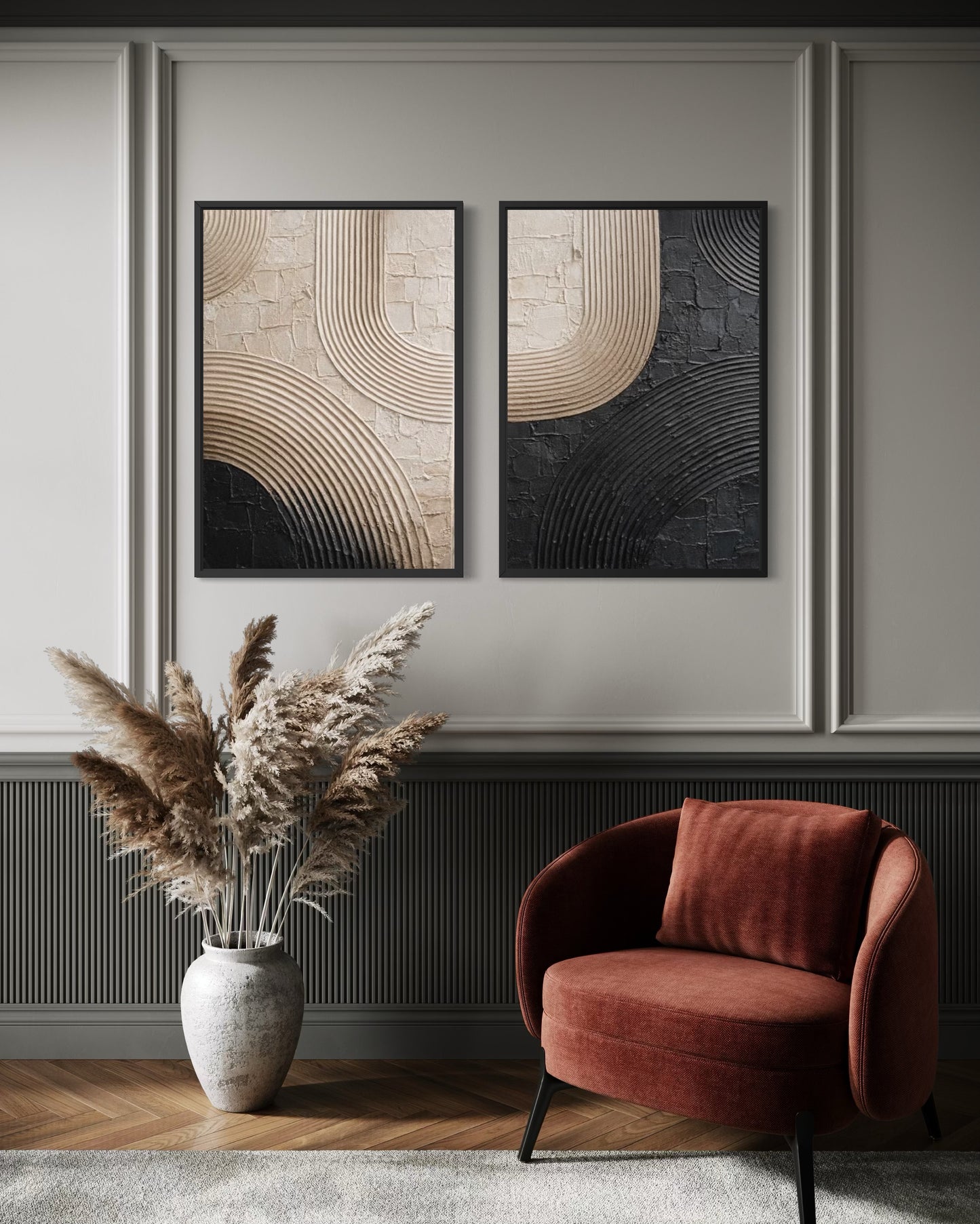 Two abstract paintings on a wall above a red armchair and decorative vase with pampas grass.