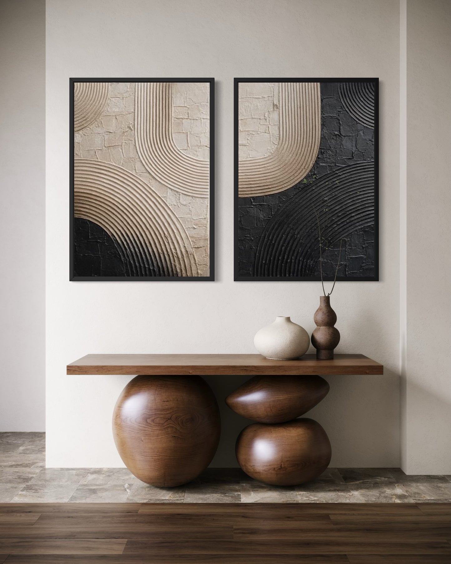 Two abstract wall art pieces above a wooden console table with decorative vases.
