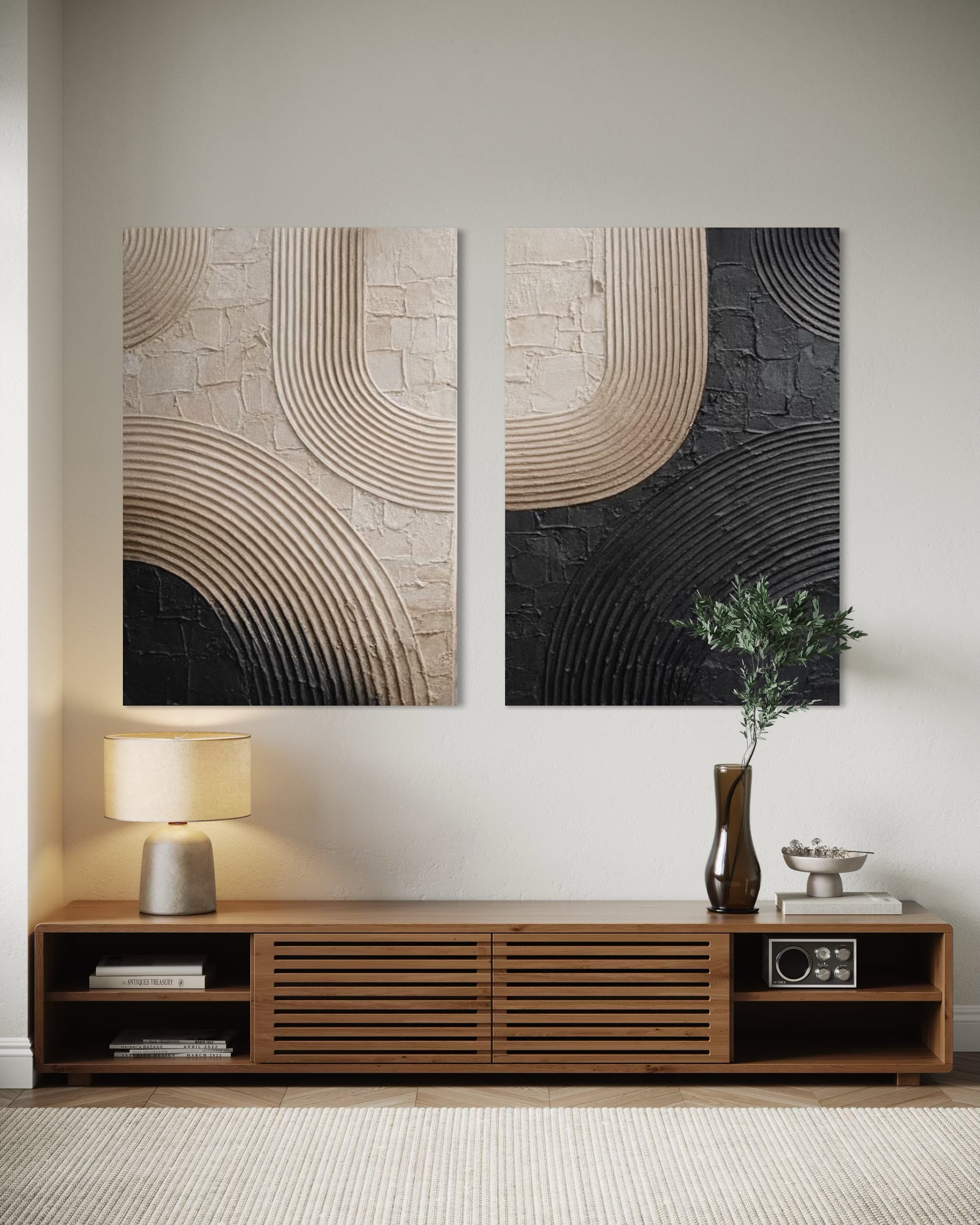 Two abstract wall art pieces above a wooden console table in a room.