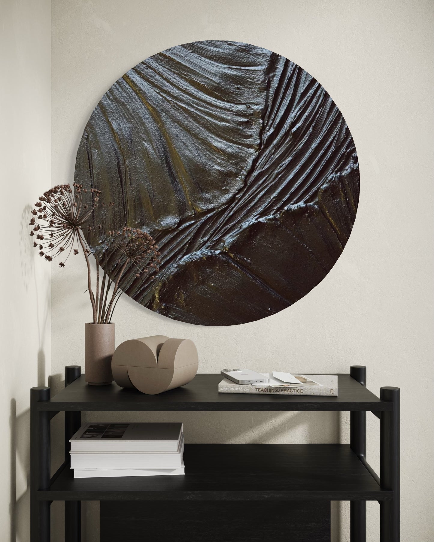 Round abstract painting on a wall above a black console table with decorative items.