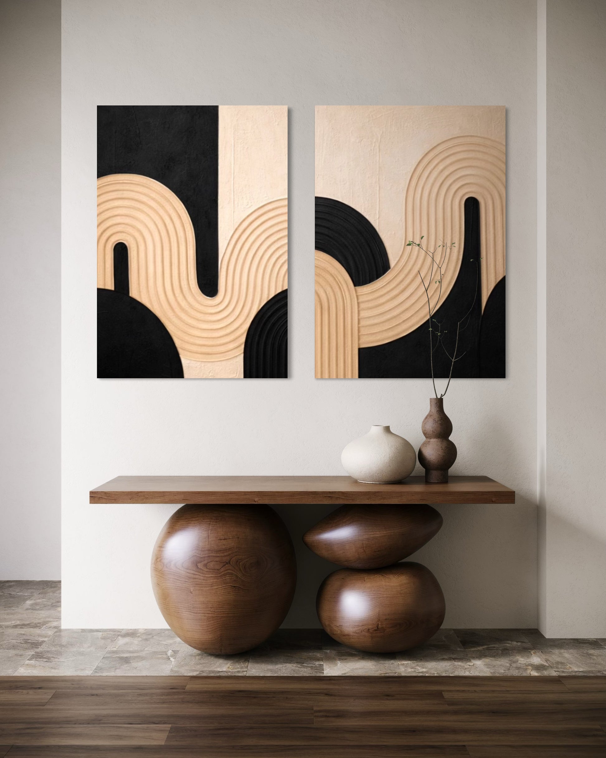 Two abstract wall art pieces on a wall above a wooden console table.