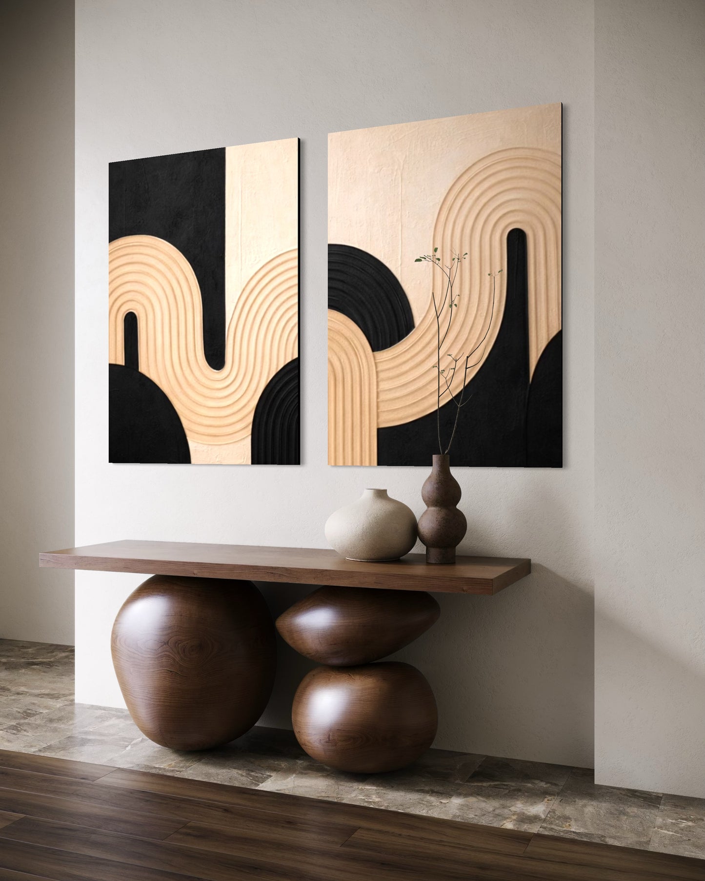 Two abstract wall art pieces on a wall above a wooden console table.