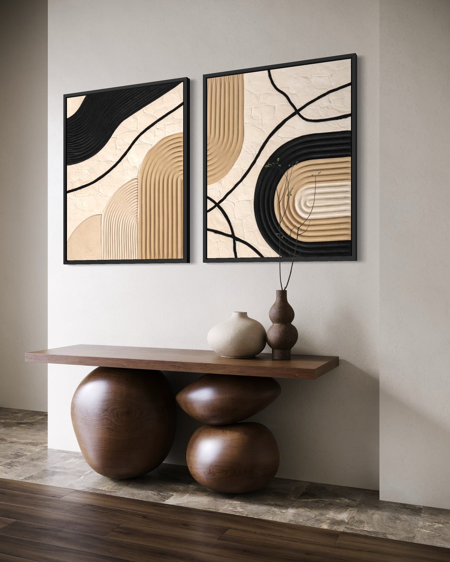 Two abstract wall art pieces on a neutral wall with a wooden console table below.