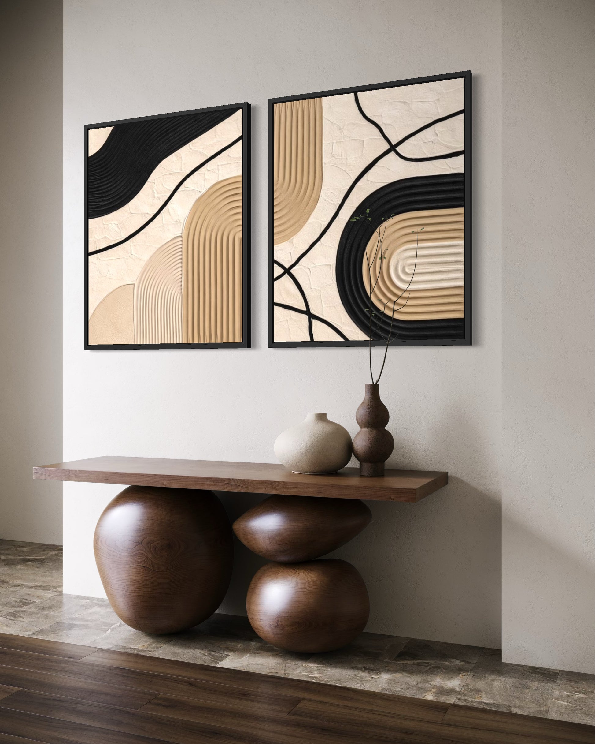 Two abstract wall art pieces on a neutral wall with a wooden console table below.