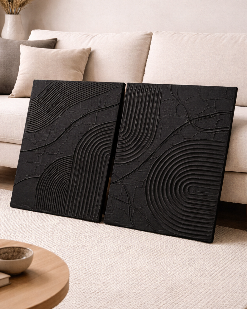 Black textured wall art in a living room setting with a beige sofa and wooden coffee table.