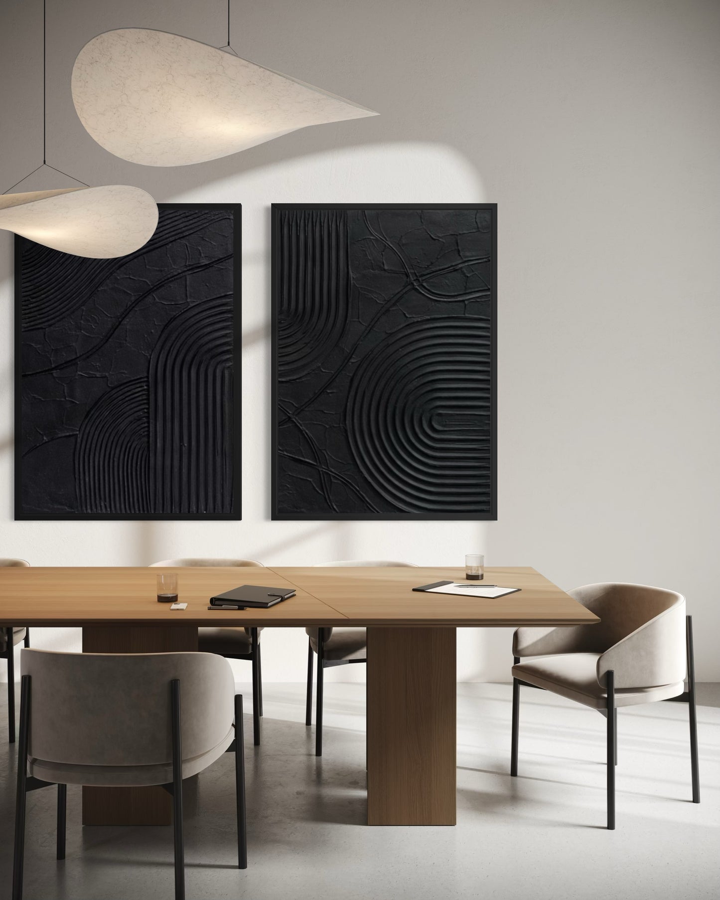 Modern dining room with wooden table and chairs, featuring two black abstract wall art pieces.