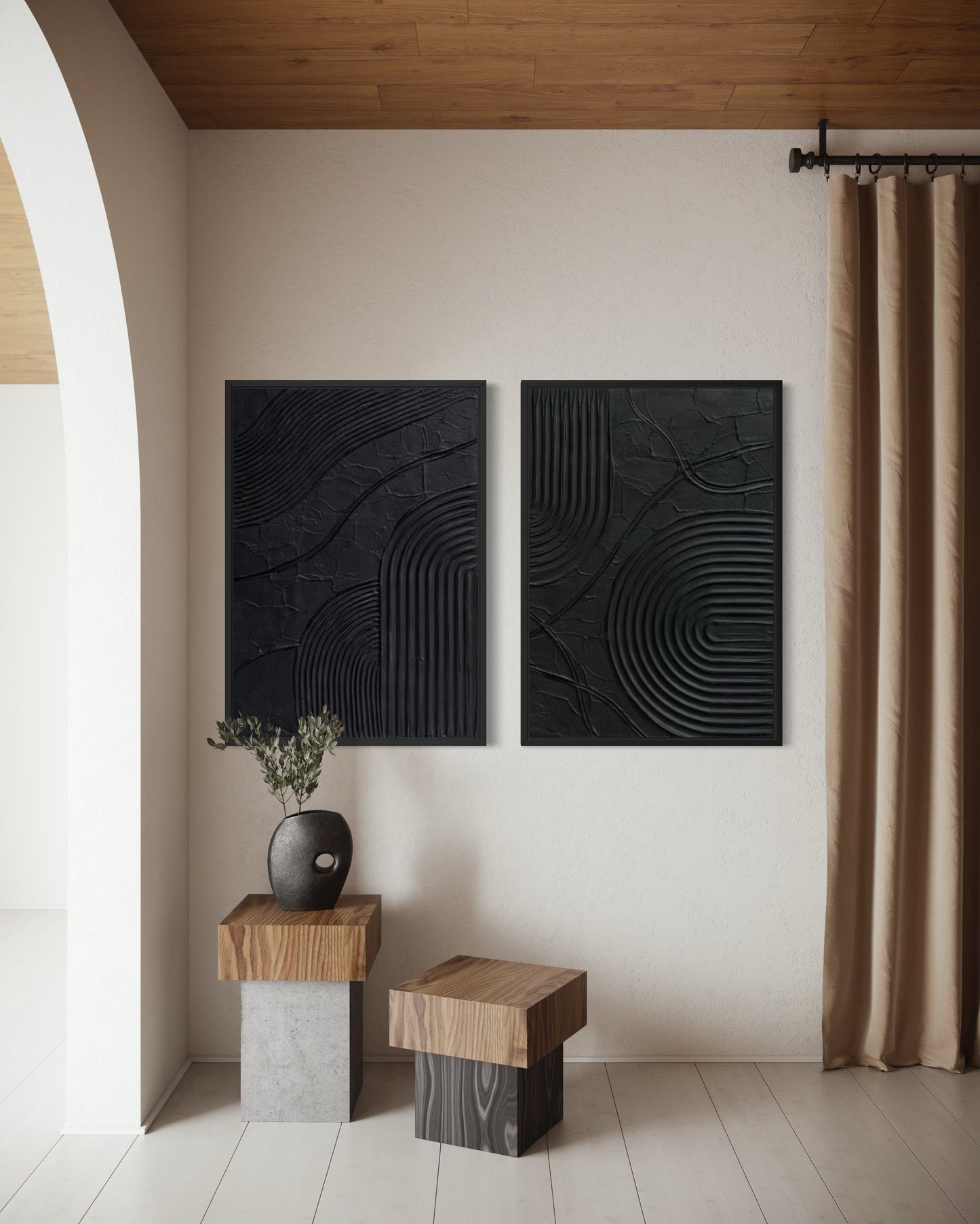 Two black abstract wall art pieces on a white wall with wooden furniture and a curtain.