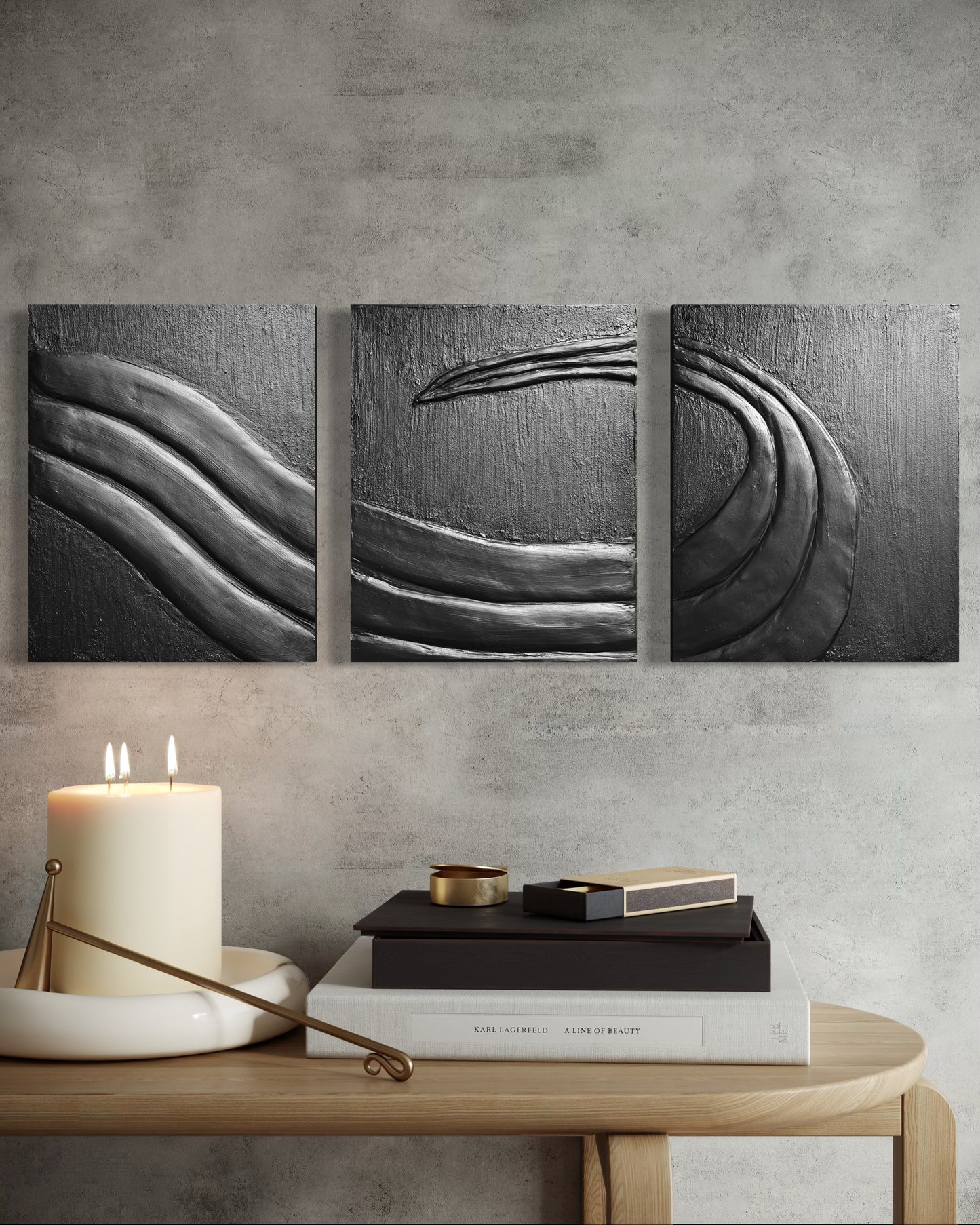 Three abstract wall art pieces on a gray wall above a wooden table with decor items.
