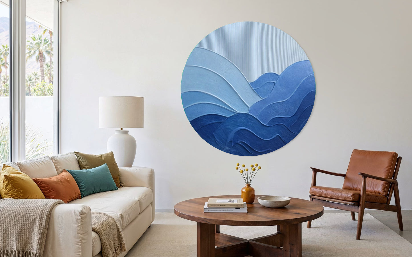 Living room with a round blue wall art piece, sofa, and chair.