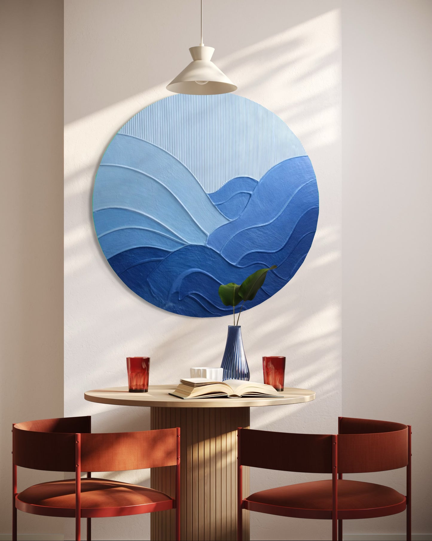 Round blue wall art piece in a room with a table and chairs.