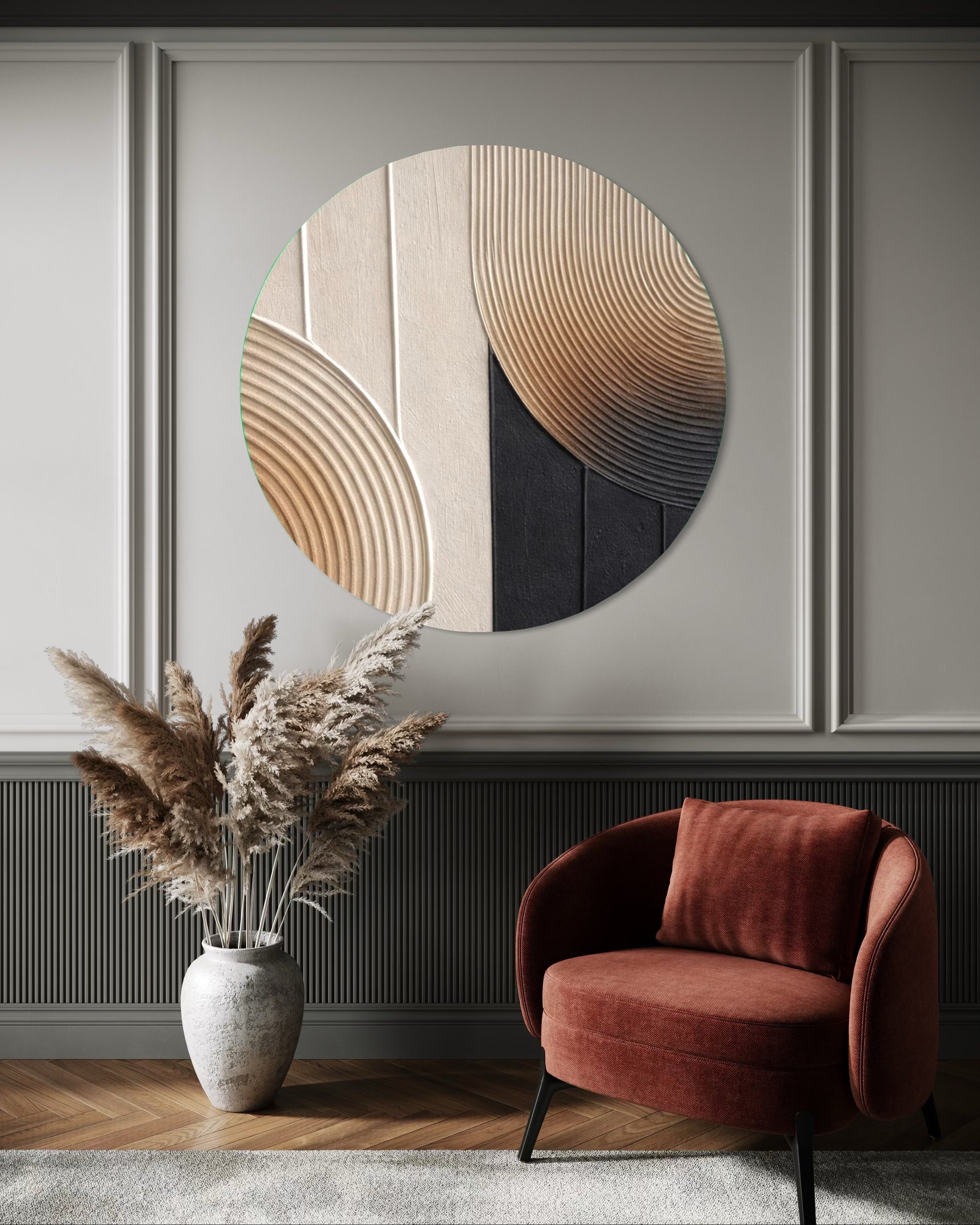 Round abstract wall art piece on a wall with a red armchair and decorative vase below.