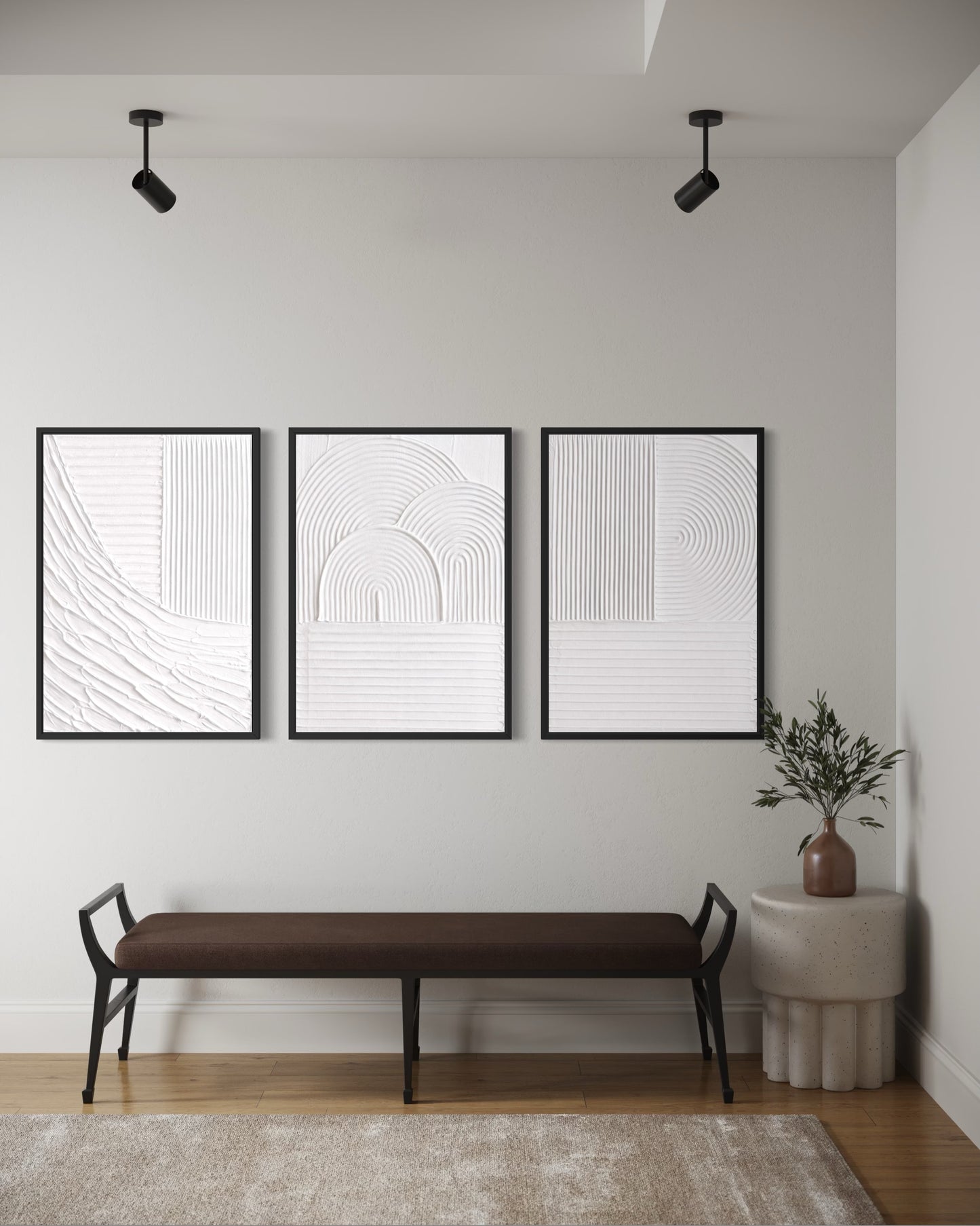 Three black-framed abstract art pieces on a wall above a brown bench.