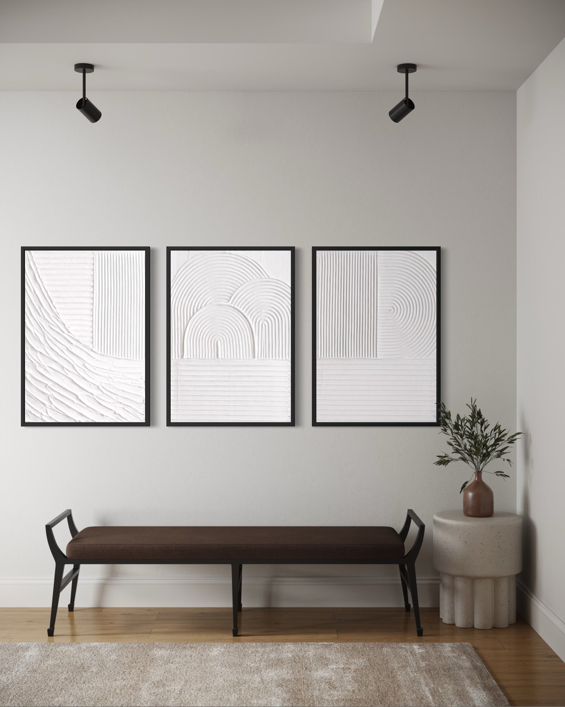 Three black-framed abstract art pieces on a wall above a brown bench.