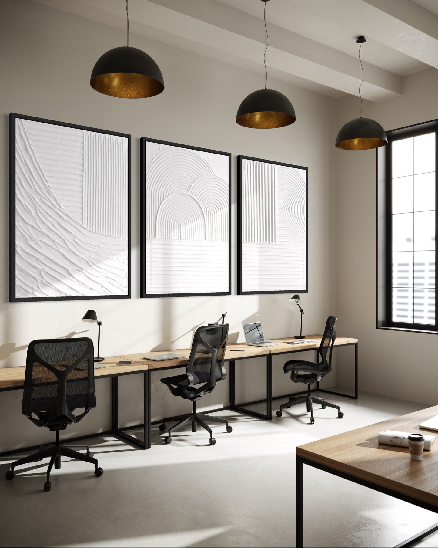 Modern office space with desks, chairs, and framed artwork on a wall.