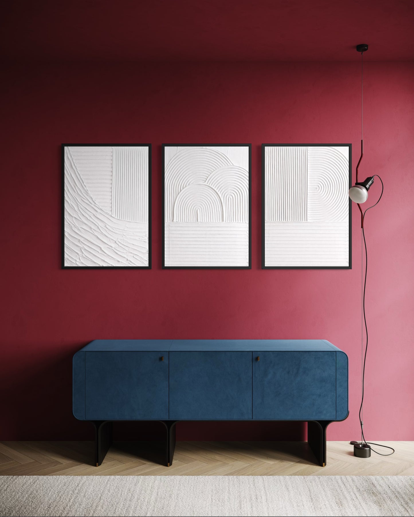 Blue bench against a red wall with three white abstract paintings