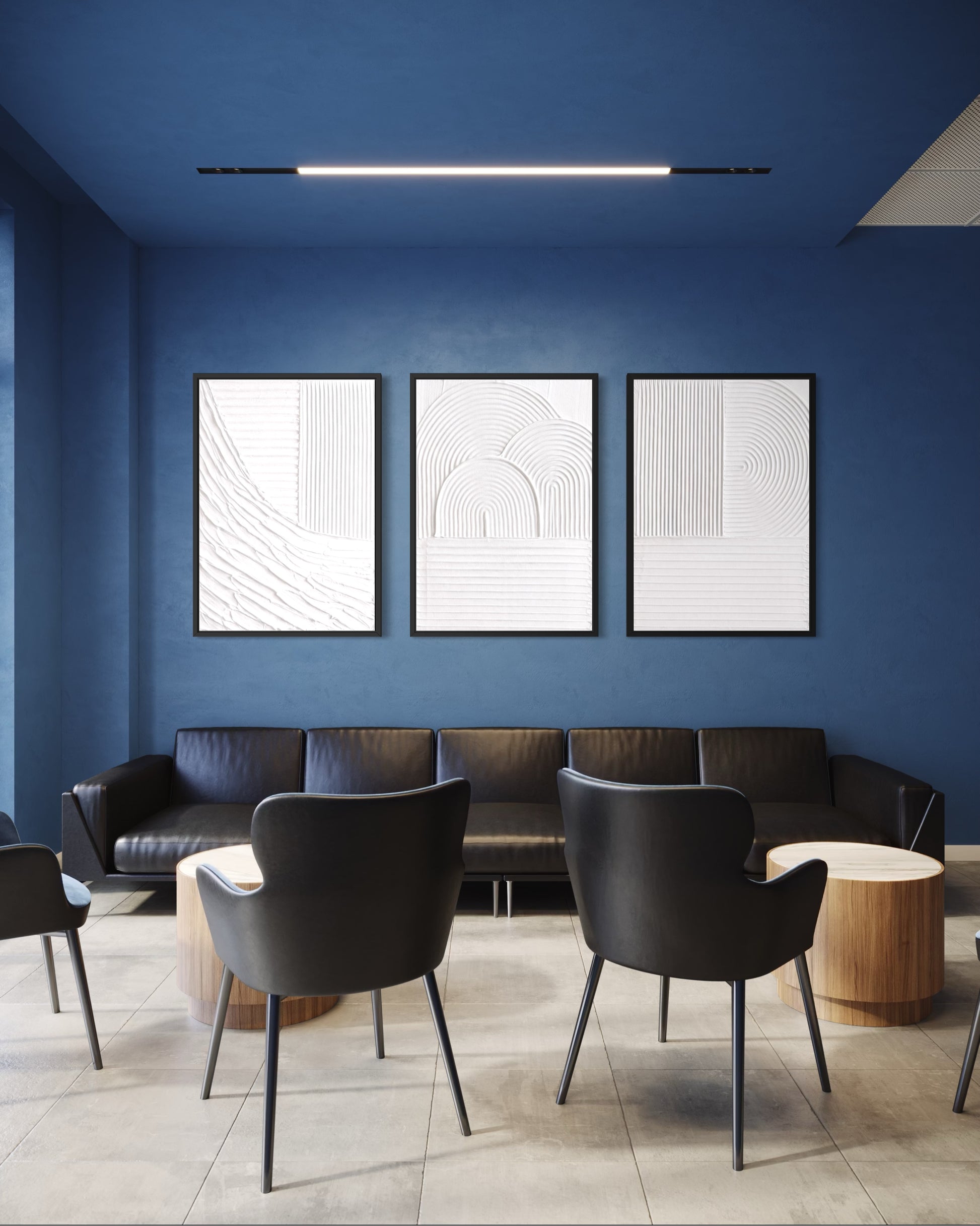 Modern waiting room with blue walls, black chairs, and abstract art.