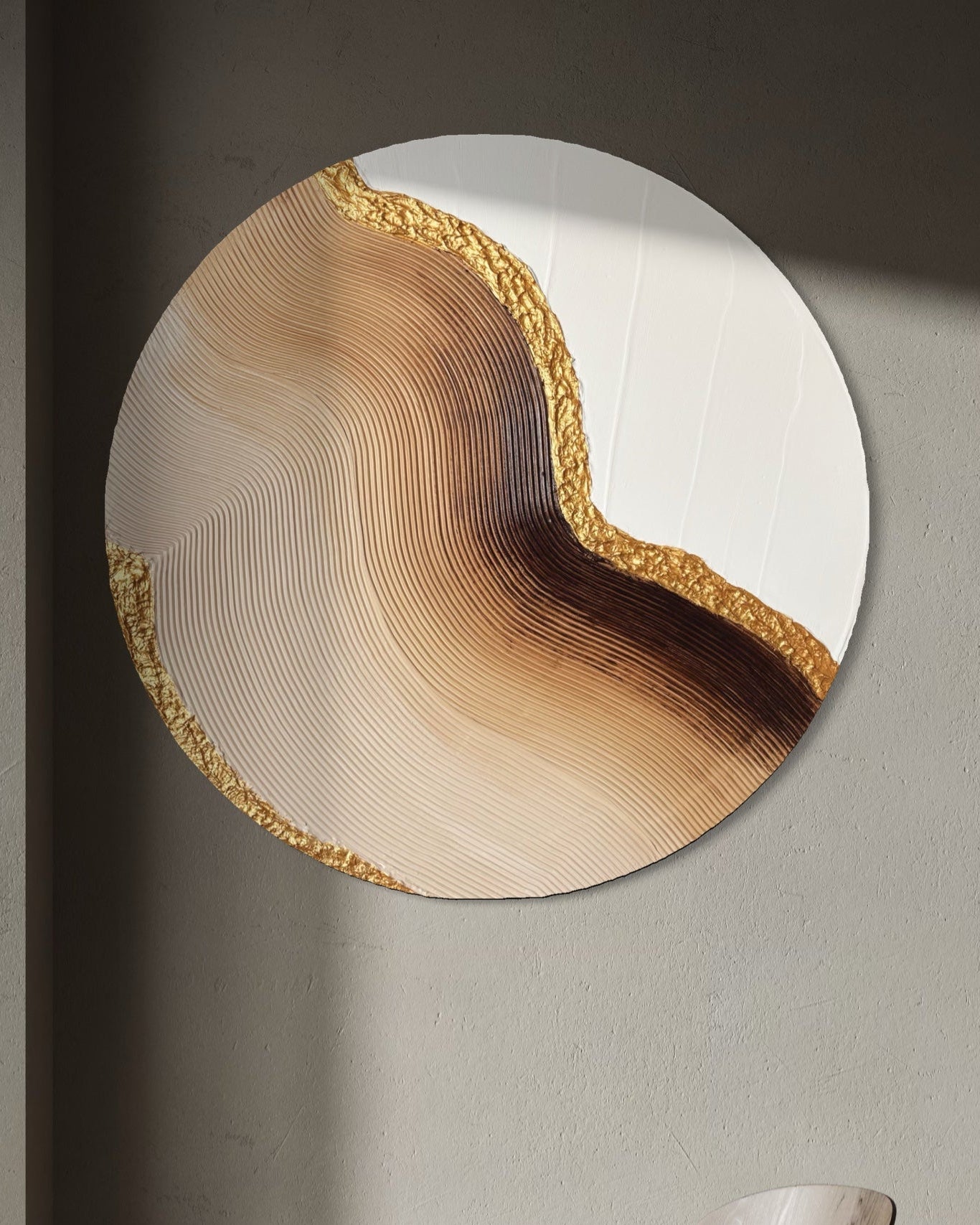 Round wall art piece with a natural wood design in a minimalistic room.