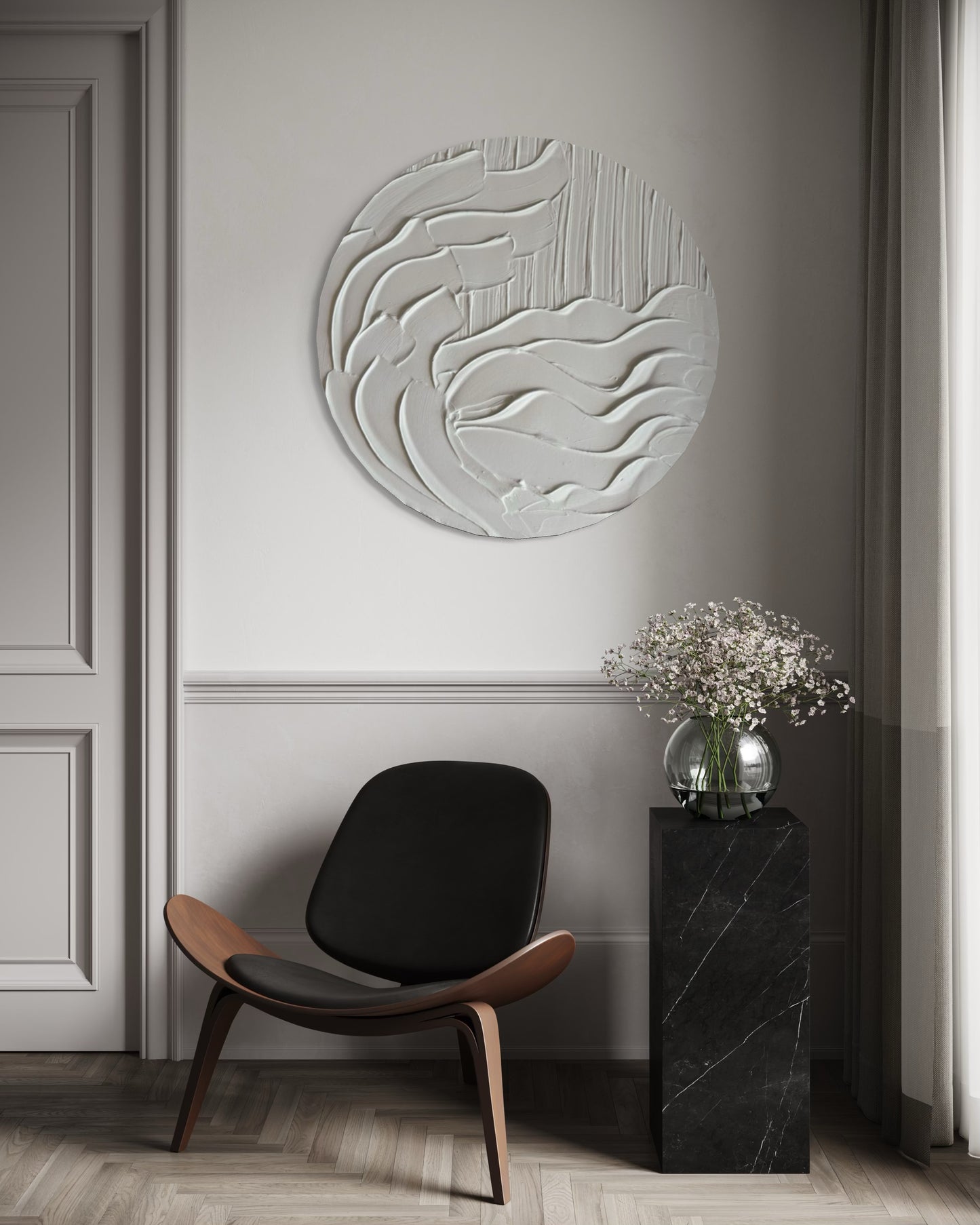 Modern interior with a black chair, decorative wall piece, and small table with flowers.