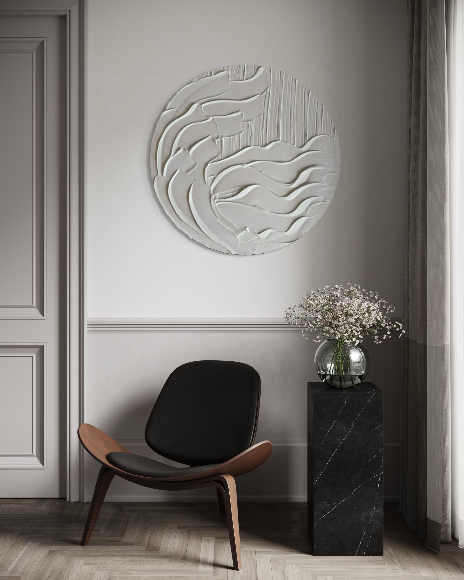Modern interior with a black chair, decorative wall piece, and small table with flowers.