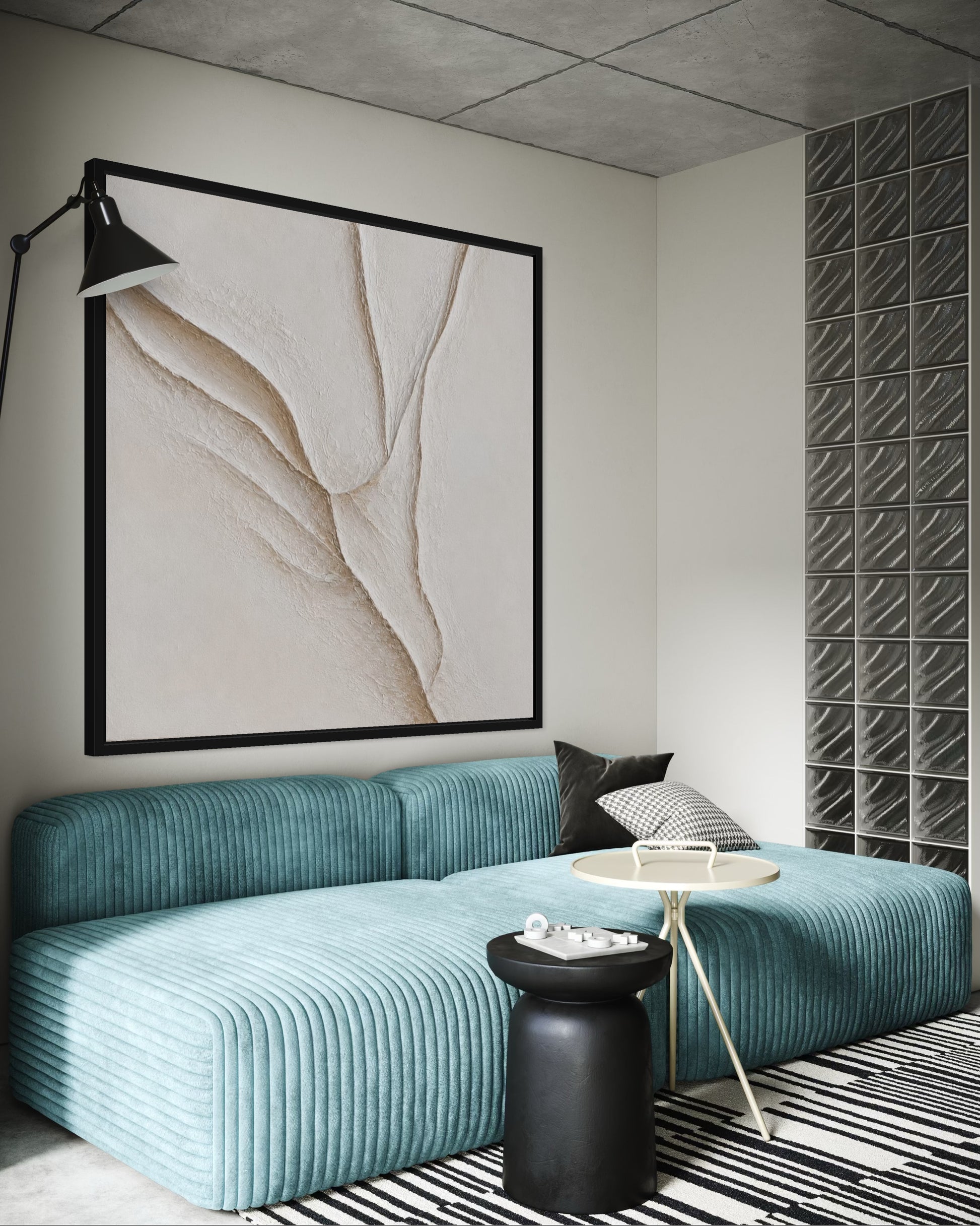 A modern living room corner featuring a large black-framed abstract art print on the wall above a teal ribbed sectional sofa. The room has a concrete ceiling, a gray textured block wall, a black floor lamp, and a black-and-white striped rug.
