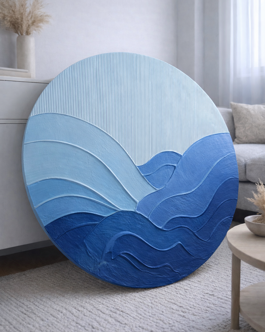 Round blue textured wall art piece in a living room setting.
