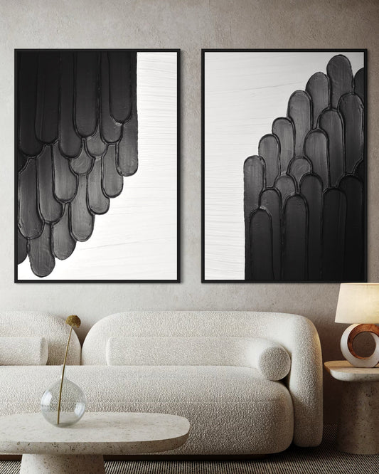 Modern living room with abstract art, set of 2 LAUMA black and white artwork beige sofa, and side table.