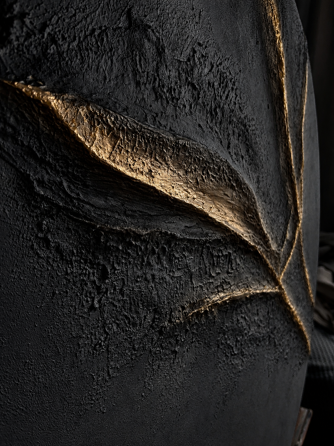 Close-up of a textured black surface with a leaf-like pattern