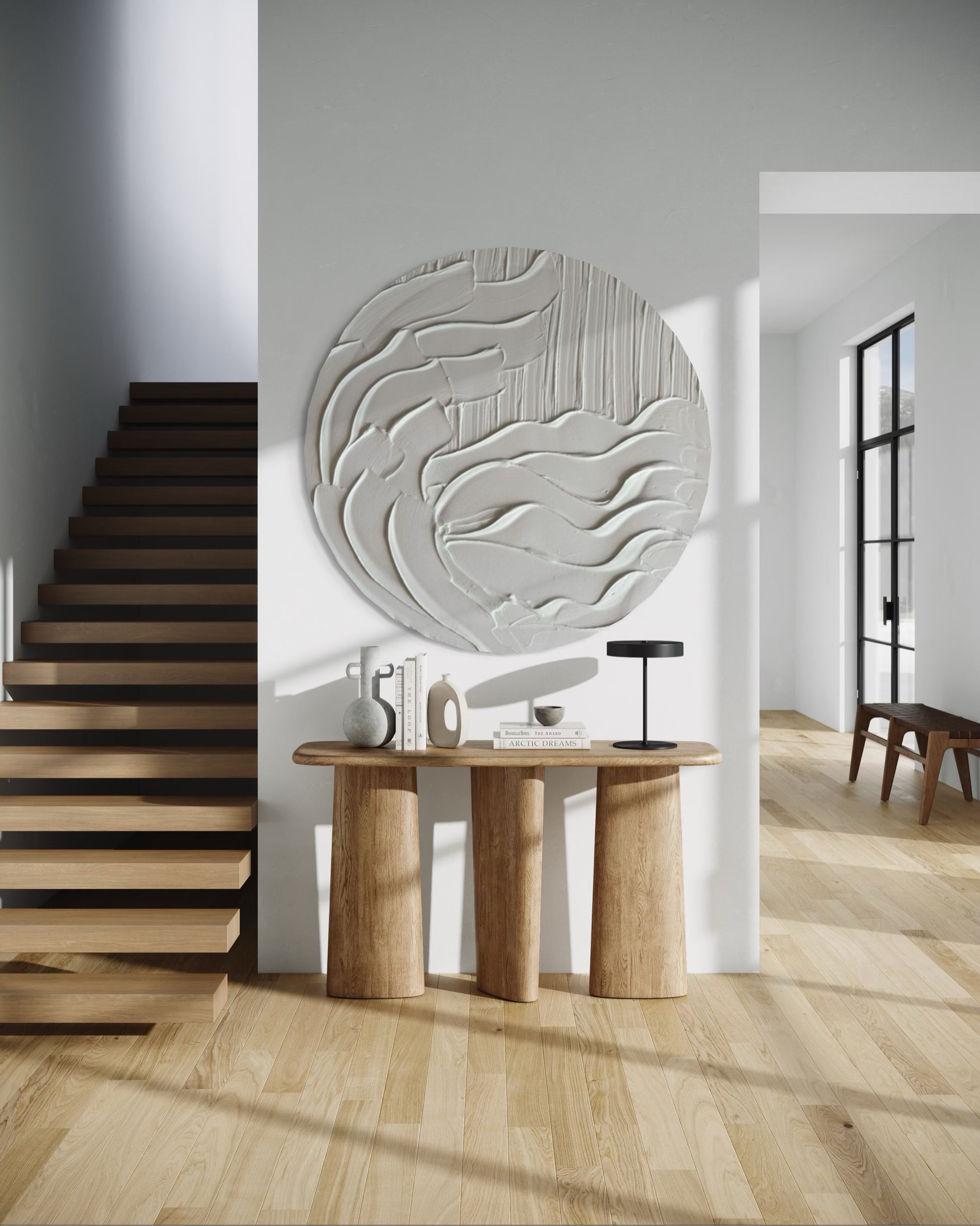 Modern interior with wooden table, minimalist textured coastal wall piece, and staircase.