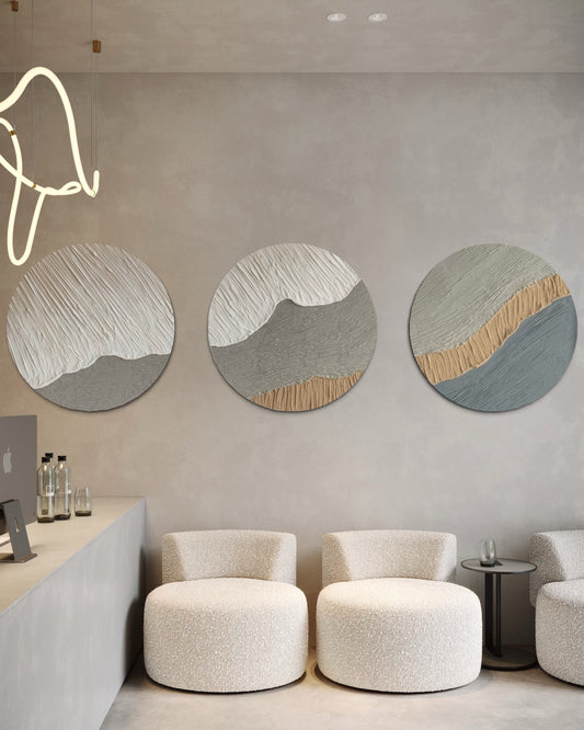 Modern interior with round abstract wall art set of 3  and white chairs.